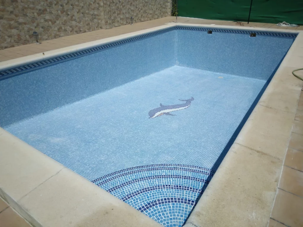 Revestimiento de piscina con mosaico antideslizante y delfín en Córdoba