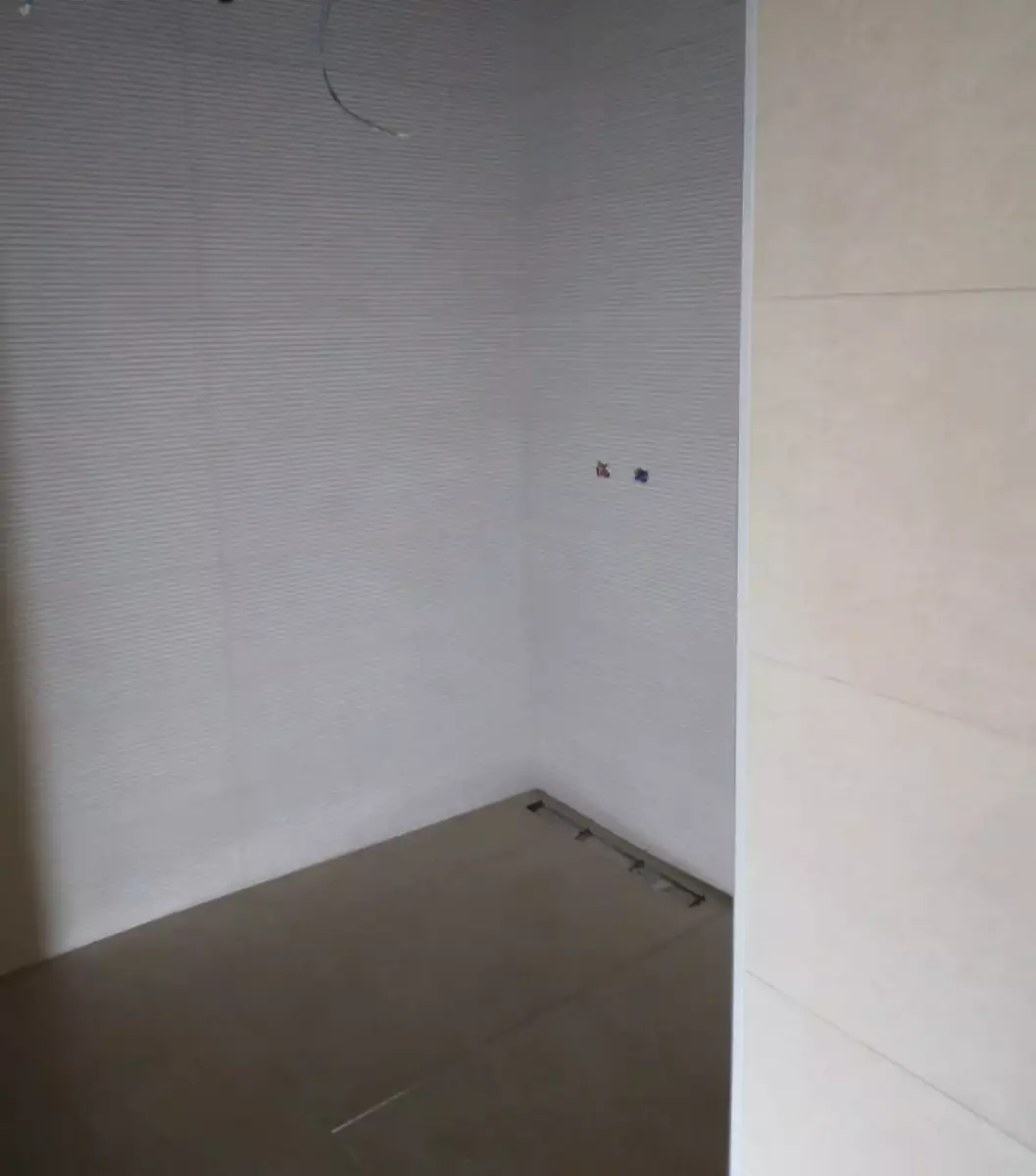 Ducha terminada con pavimento porcelánico beige y pared texturizada en Córdoba