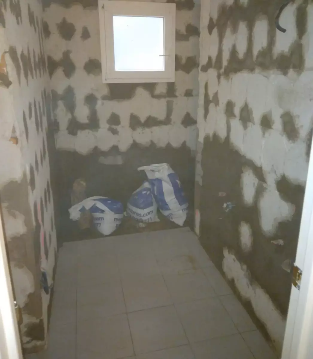 Baño en obra antes de la reforma, paredes enfoscadas en Córdoba