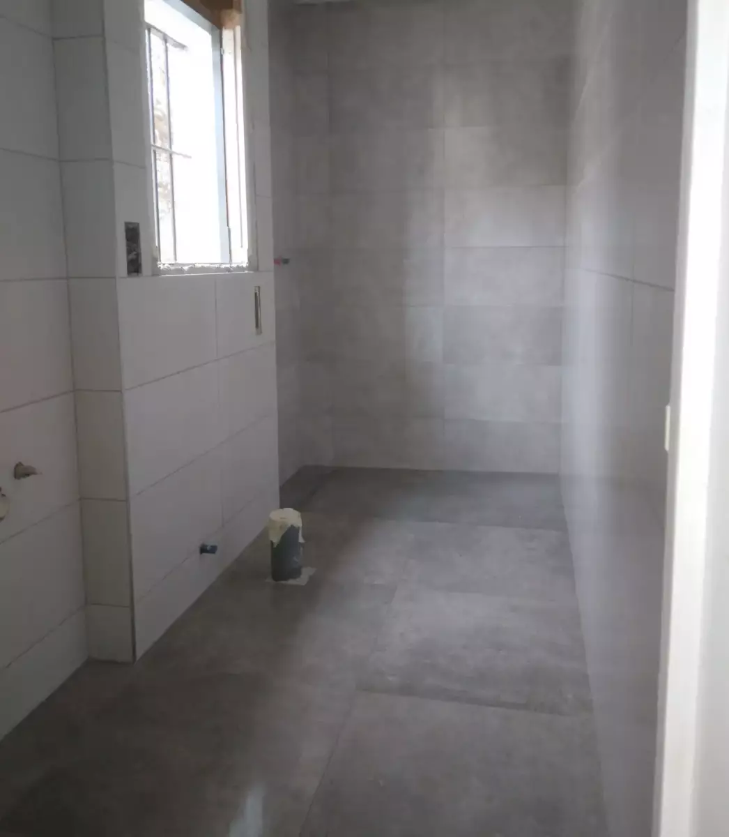 Baño reformado con revestimiento cerámico gris y blanco en Córdoba