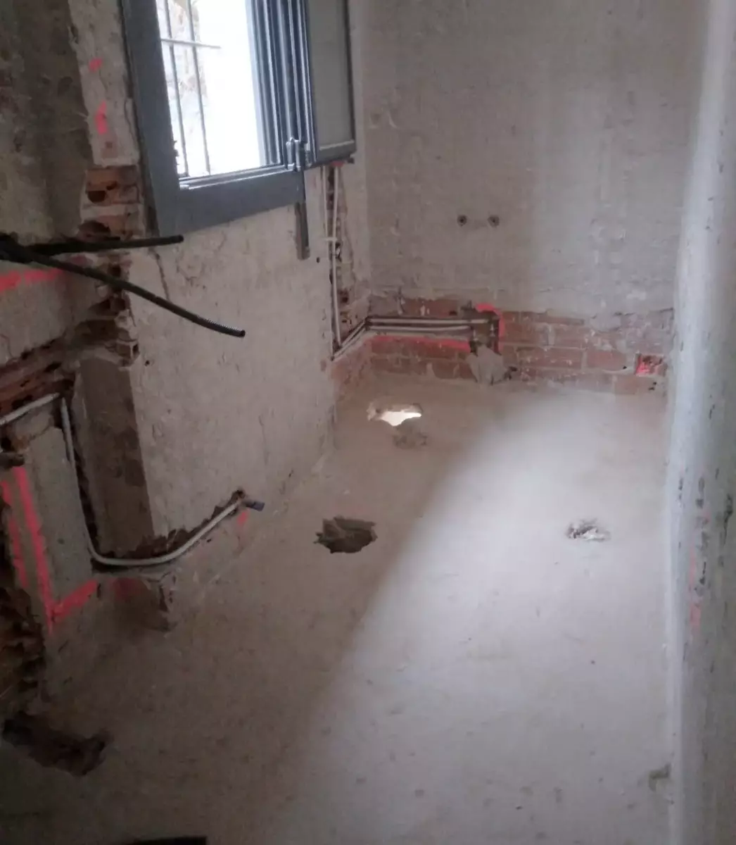 Baño antes de la reforma con rozas e instalaciones a la vista en Córdoba